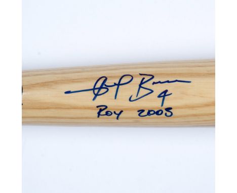 A light wood-colored bat with a blue accent ring and black text, autographed by Angel Berroa. Rawlings marked. Dimensions: 33