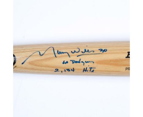 This is a Rawlings Big Stick Professional Model baseball bat, natural wood-colored, and signed by Maury Wills in blue with hi