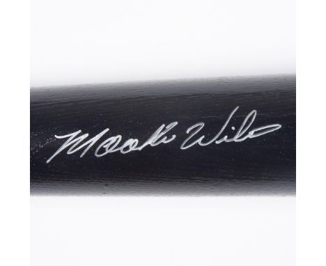 A black Rawlings baseball with silver-colored text and accents, with Mookie Wilsons autograph in silver ink. Rawlings marked.