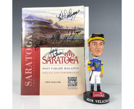 A bobblehead of John Velazquez in his yellow and blue jockey uniform, holding his jockey stick, comes with an autographed box