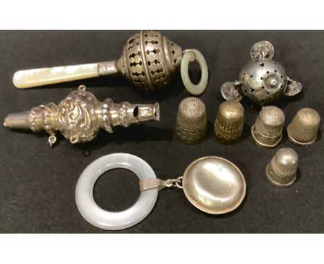A silver and mother-of-pearl baby's rattle, Birmingham 1920; others; a silver thimble, Chester 1921; other silver thimbles 