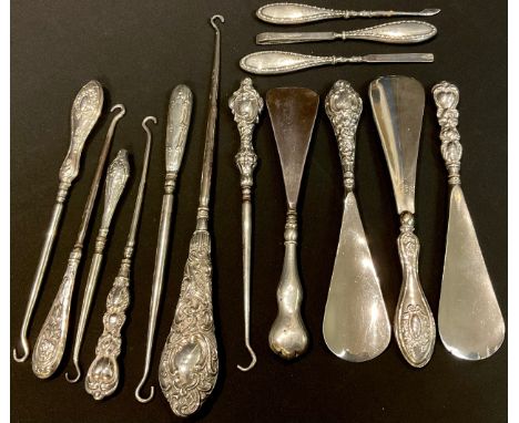 A collection of Victorian and later silver hafted shoe horns, button hooks and manicure tools 