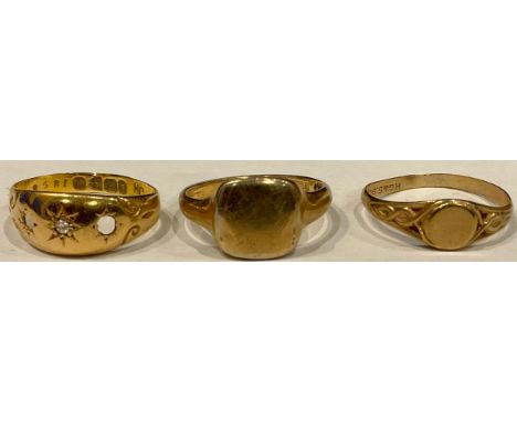 A 9ct gold ring, size J, 2.9g; another 9ct gold ring, size J, 0.7g; an 18ct gold ring, size J, lacking two stones, 1.9g (3) 