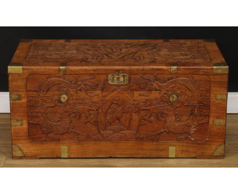A Chinese inspired brass mounted camphor lined chest or trunk, the exterior carved with dragons, 44.5cm high, 98cm wide, 48.5
