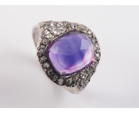 AN LATE 18TH CENTURY AMETHYST AND DIAMOND RING, the large oval faceted cut amethyst set within a surround of old cut diamond 