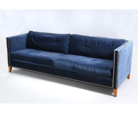 MITCHELL GOLD & BOB WILLIAMSA DEEP BLUE UPHOLSTERED SOFA, with brass studs and square section tapering legs. 94 inches wide (