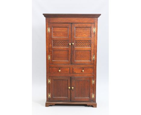 AN EARLY 19TH CENTURY OAK FOOD CUPBOARD, NORTH WALES, with moulded projecting cornice above a pair of doors, each with a pair