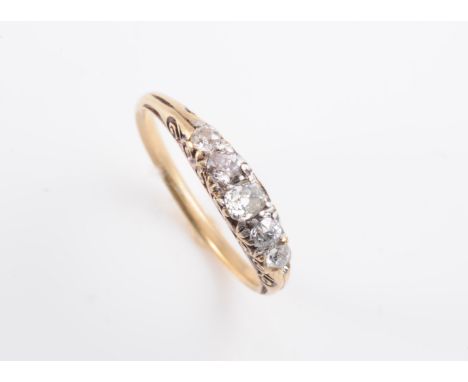 A LATE VICTORIAN DIAMOND SET RING, the five graduating old brilliant cut diamonds set in a pierced scroll detail mount betwee