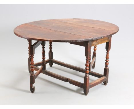 AN 18TH CENTURY RED WALNUT GATELEG TABLE, the oval dropleaf top raised on bobbin, reel and pear turned supports and gateleg p