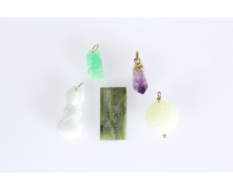 A GROUP OF FIVE CHINESE PENDANTS, four jade and one amethyst, including one bun shaped and pierced, another carved as a godde