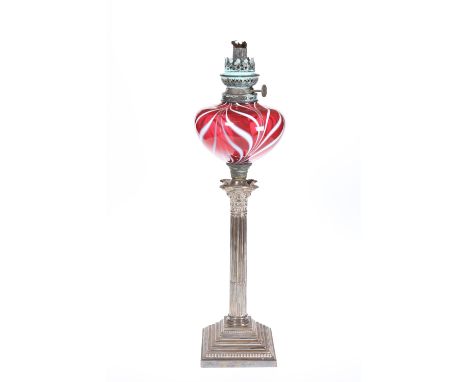 A SILVER-PLATED COLUMNAR OIL LAMP, c. 1900, the Corinthian columnar stem on a stepped square base, beneath a ruby glass reser