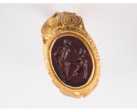 A ROMAN RING, 2ND-4TH CENTURY, the oval carved intaglio depicting Achilles and Patroclus, set within a heavy mount of coiled 