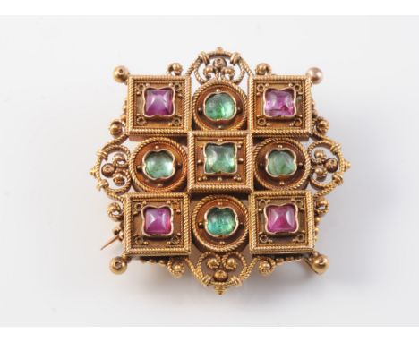 A LATE 19TH CENTURY RUBY AND EMERALD SET BROOCH IN THE MANNER OF CASTELLANI, the shield shaped mount of symmetrical design of