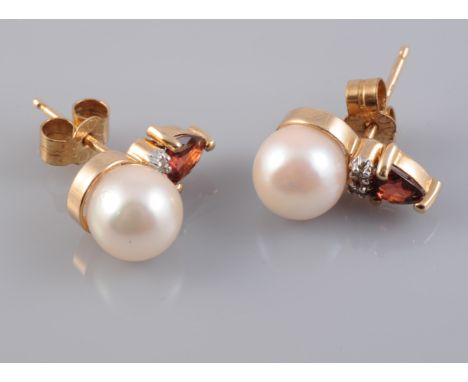 A PAIR OF CULTURED PEARL, DIAMOND AND GARNET SET EARRINGS, the single cultured pearl set beneath a heart cut garnet and two d