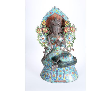 A SINO-TIBETAN CLOISONNE ENAMEL FIGURE OF A FEMALE DEITY, depicted enthroned and crowned amidst floral sprays, on a waisted s