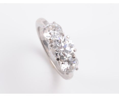 A DIAMOND RING, the three graduating brilliant cut diamonds each claw set in a simple pierced mount between solid tapering sh
