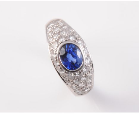 AN 18CT WHITE GOLD, SAPPHIRE AND DIAMOND RING, the single oval cut sapphire collet set to the centre of a bombe shaped mount 