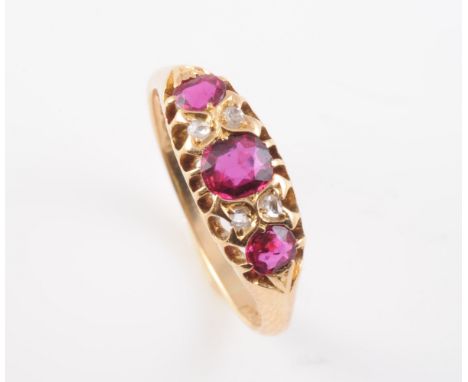 A MID VICTORIAN RUBY AND DIAMOND RING, the three graduating round mixed cut rubies set in a simple pierced detail mount with 