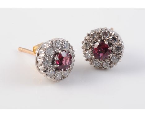 A PAIR OF RUBY AND DIAMOND CLUSTER EARRINGS, the single round cut ruby claw set within a surround of nine brilliant cut diamo