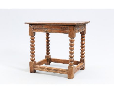AN OAK SIDE TABLE, late 17th Century and later, the plank top above a moulded frieze, raised on bobbin turned legs continuing