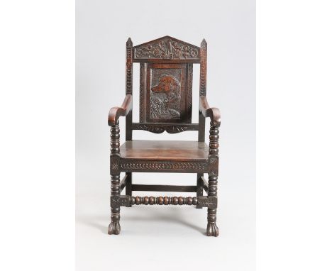 A 17TH CENTURY STYLE OAK WAINSCOT CHAIR, 19TH CENTURY, the pointed arch crest carved with a heron and four stylised flowerhea