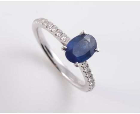 AN 18CT WHITE GOLD, SAPPHIRE AND DIAMOND RING, the oval cut sapphire four claw set raised in a pierced open mount between tap