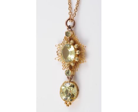 A PERIDOT SET PENDANT, the round mixed cut peridot suspending on an articulated link from a star shaped mount of stranded met