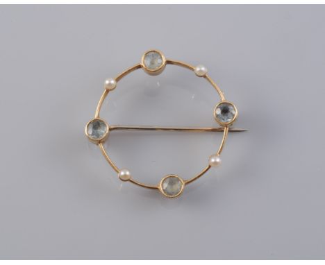 AN AQUAMARINE AND SEED PEARL BROOCH, circa 1910-1915, the fine knife edge roundel mount set with four evenly spaced seed pear