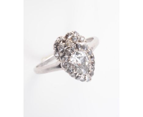 AN EARLY 19TH CENTURY DIAMOND SET RING, the oval mixed cut diamond set within a shield shaped mount set with old brilliant cu