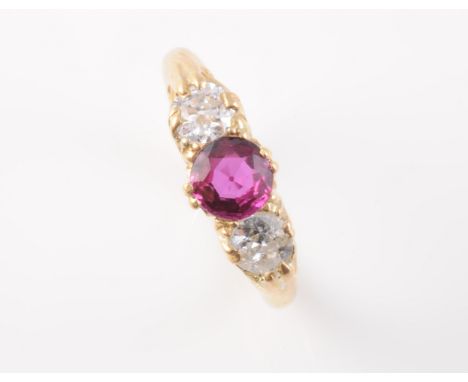 A LATE 19TH CENTURY RUBY AND DIAMOND RING, the single round cut ruby set between two brilliant cut diamonds, all set in a sim