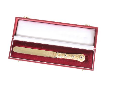 A LATE 19th CENTURY GEM-SET GOLD (UNMARKED) PAPER KNIFE, the blade with engraved decoration on a handle elaborately cast with