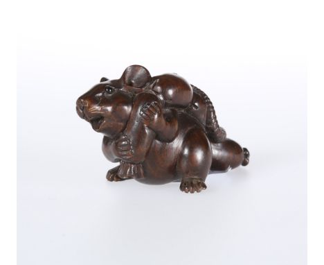A JAPANESE WOODEN NETSUKE, carved as a mouse pulling a sack, signed. 32mm high