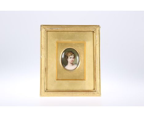 A CONTINENTAL PAINTED PORCELAIN PORTRAIT MINIATURE, CIRCA 1900, oval, of a lady wearing hair ornament, in a gilt frame under 