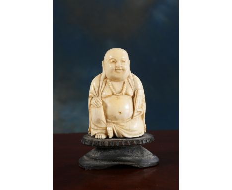 A 19TH CENTURY CHINESE CARVED IVORY BUDDHA, modelled wearing bead necklace and holding a scroll, on carved wooden base. Overa