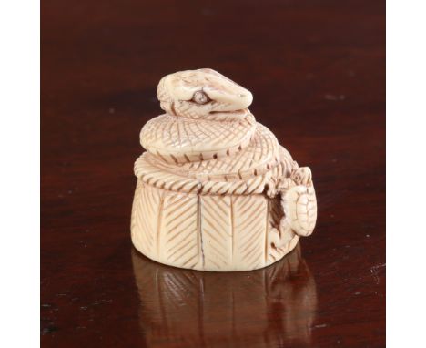 A JAPANESE IVORY NETSUKE, Meiji period, carved as a coiled snake emerging from a basket with a tortoise climbing the side, si