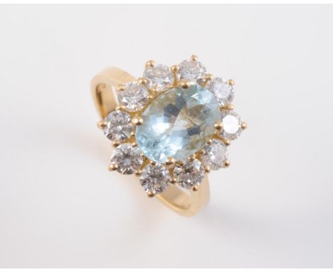 AN 18CT YELLOW GOLD, AQUAMARINE AND DIAMOND RING, the oval cut aquamarine claw set within a surround of ten brilliant cut dia