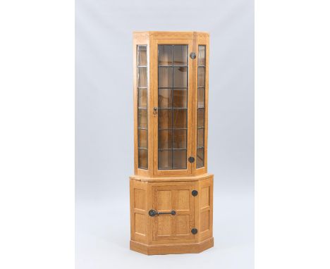 ROBERT THOMPSON OF KILBURNA MOUSEMAN OAK CORNER CABINET, with penny moulded frieze above a lead glazed door and side panels, 