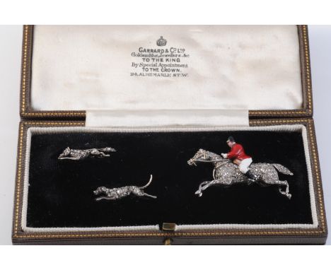 A LATE 19TH CENTURY HUNTSMAN, HOUND AND FOX BROOCH SET BY GARRARD &amp; CO, the galloping horse set throughout with graduatin