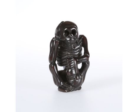 A JAPANESE WOODEN NETSUKE OF A SKELETON, signed. 5cm