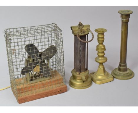A Vintage Fan with Wire Surround Guard Together with Two Brass Candlesticks and a Burner 
