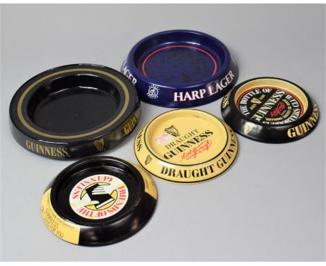 A Collection of Four Guinness and Harp Pressed Metal Advertising Ashtrays 