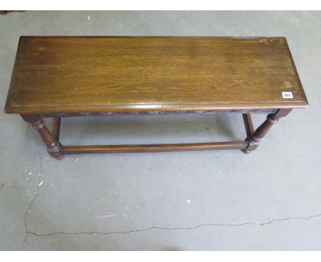 An oak long stool with a carved frieze. 91 cm long x 29 cm deep x 45 cm tall