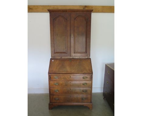 A George III mahogany bureau with four full length graduated drawers standing on bracket feet inlaid fall with fitted interio