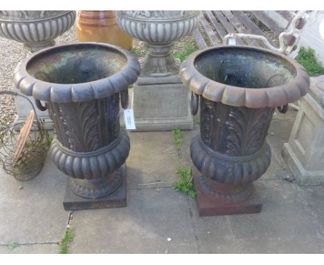 A pair of large black painted metal garden planter urns with foliate design and ring handles 78cm high x 55cm diameter
