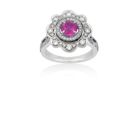 A Pink Sapphire and Diamond Cluster Ringthe round cut pink sapphire within a border of round brilliant cut diamonds, to a fur