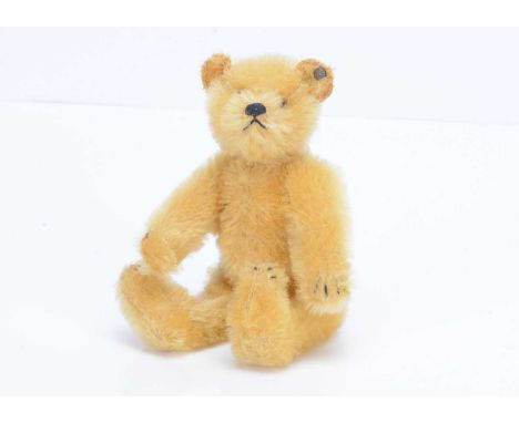 A small 1920s Steiff teddy bear,  with golden mohair, brown and black glass eyes, black stitched nose, mouth and claws, swive