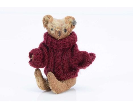 A Steiff miniature teddy bear, circa 1910, with remains of blonde mohair, black bead glass eyes, swivel head, jointed limbs, 