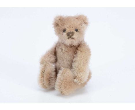 A 1920-30s Steiff miniature teddy bear,  with light brown mohair, black glass eyes, black stitched nose, swivel head and join
