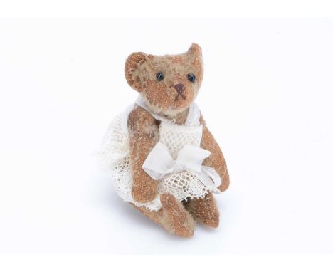 A Steiff miniature teddy bear, circa 1910,   with blonde mohair, black bead glass eyes, brown stitched nose and mouth,  FF un