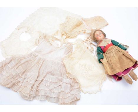 Baby and doll’s clothes and lace, a pink muslin doll’s dress with frills —13in. (33cm.) high, worked net two bonnets, a gown 